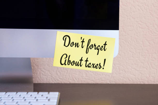 istock modern computer with reminder yellow sticker note with text: don't forget about taxes! 943062184