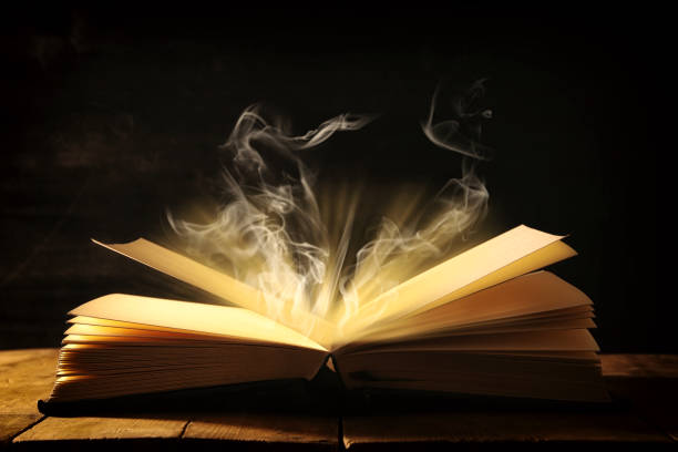 istock image of open antique book over wooden table. 943062670