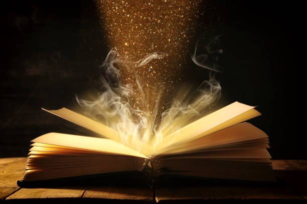 istock image of open antique book over wooden table. 943062812