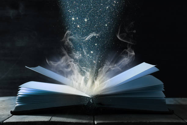 istock image of open antique book over wooden table. 943063036