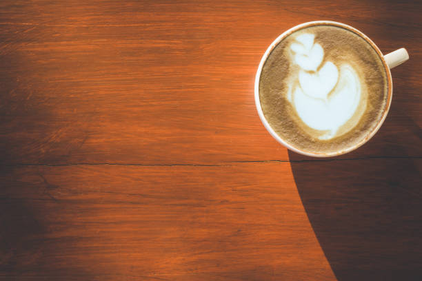 istock Hot latte coffee in white cup on wooden table with copy space for text or design 943063902