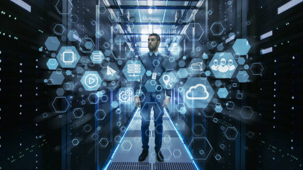 Curios IT Engineer Standing in the Middle of a Working Data Center Server Room. Cloud and Internet Icon Visualization in the Foreground.