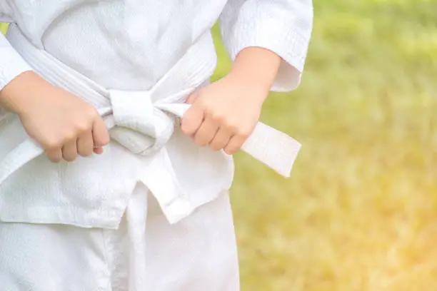 Photo of kid knots a belt that ready to training karate