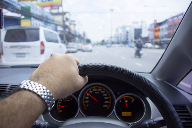 istock The driver used left hand to drive on the road. 943070214