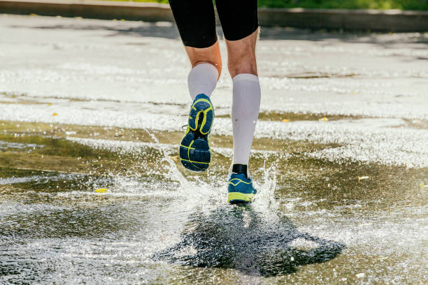 istock legs runner athlete in white compression socks running water 943070982