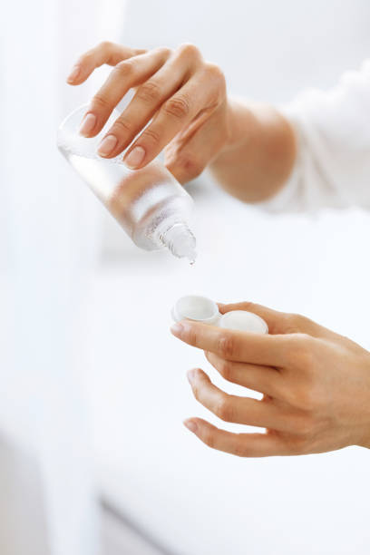 istock Woman Hands Putting Liquid From Bottle To Lens Box 943080910