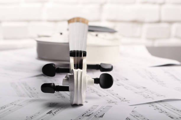 istock Close view of a violin and musical notes near white brick wall 943081332
