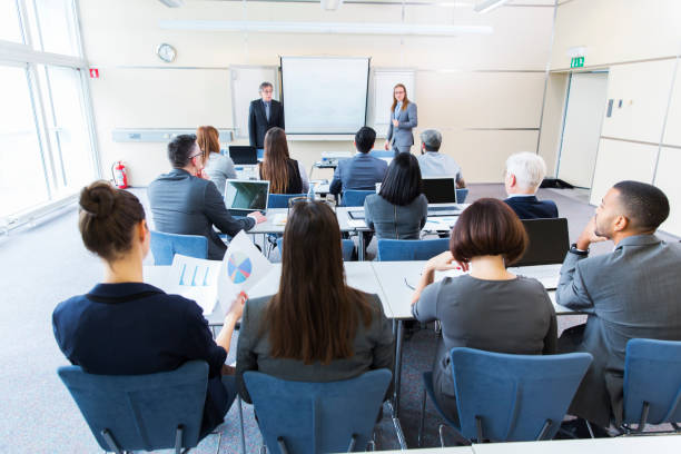 Business people in a classroom listening lecturers