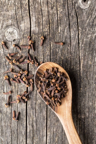 The clove spice in wooden spoon. Top view. The clove spice in wooden spoon. Top view. clove spice photos stock pictures, royalty-free photos & images