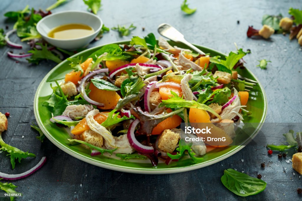 Fresh salad with chicken breast, peach, red onion, croutons and vegetables in a green plate. healthy food Fresh salad with chicken breast, peach, red onion, croutons and vegetables in a green plate. healthy food. Salad Stock Photo