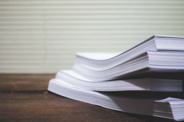 istock Stack of business report paper file on wooden table. 943109766