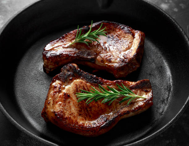istock Cooked Pork Loin chops in rustic skillet, pan with rosemary 943109924