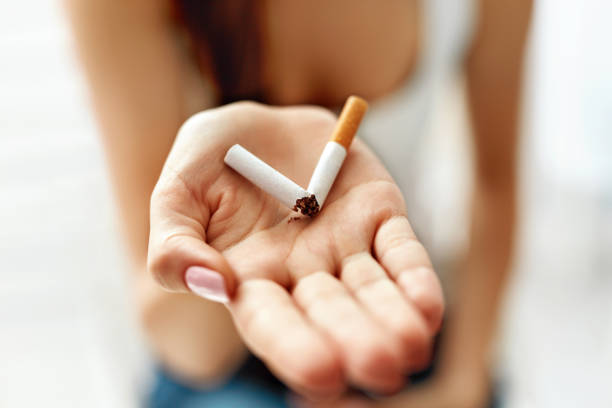 手のひらに壊れたタバコを持っている女性の手のクローズ アップ - anti smoking ストックフォトと画像