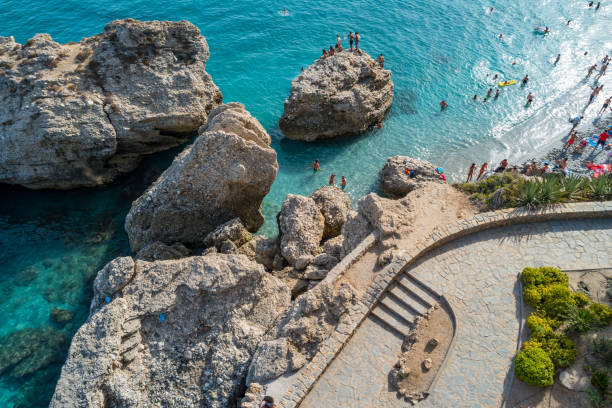 People enjoy a sunny day at the beach in Nerja, Costa del Sol, Andalusia, Spain.