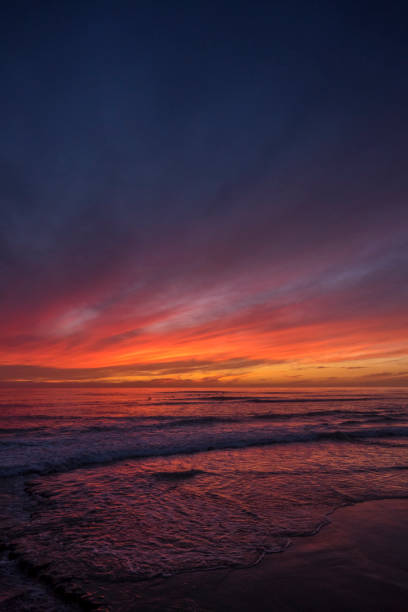 Pink sunset at Swami's Beach over the ocean in Encinitas, San Diego, California.