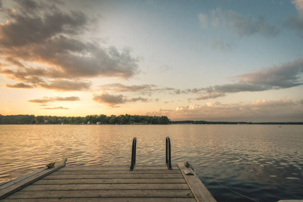 istock Sunset over a lake with a dock and ladder 943123626