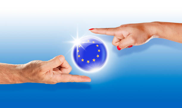 istock European Union button flag floating between with human hands 943126402