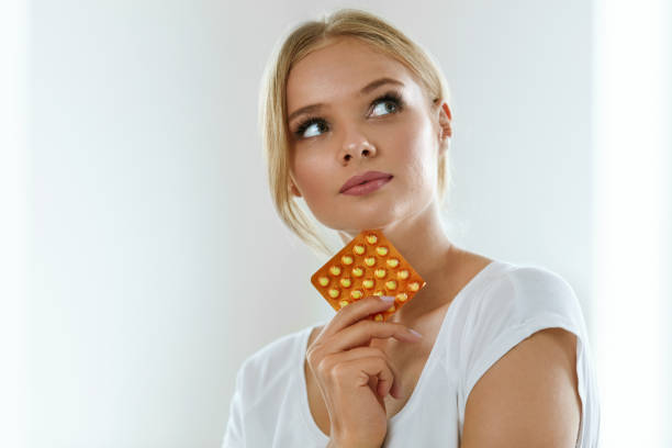 beautiful woman holding birth control pills, oral contraceptive - contraceção imagens e fotografias de stock