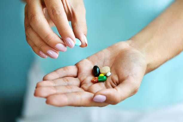 istock Vitamins And Supplements. Female Hand Holding Colorful Pills 943129676