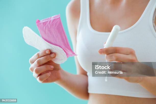 Young Woman With A Menstrual Compress And A Tampon On Blue Background Stock Photo - Download Image Now