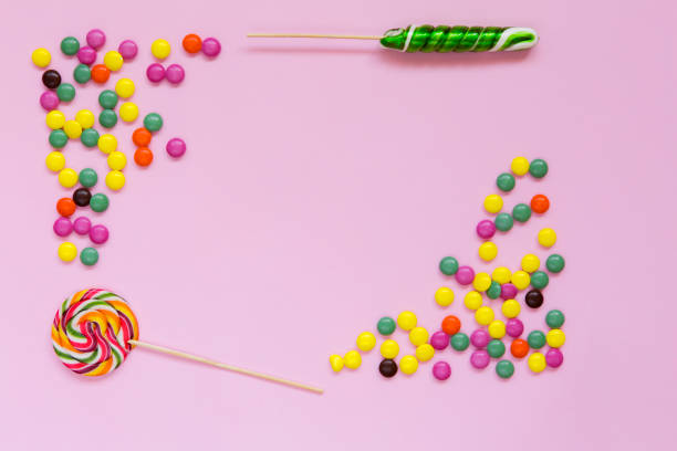 Colorful candies and lollipops on pink background