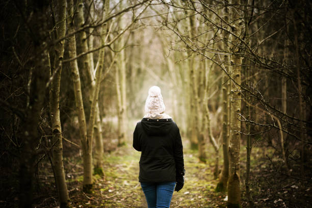 ragazza avvolta calda in un bosco misterioso. - forest single lane road spooky winter foto e immagini stock