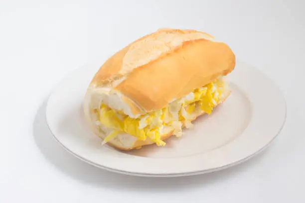 Bread with scrambled egg on white background. Brazilian Pao com ovo