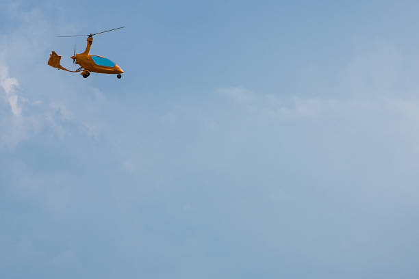 istock Small and Light Orange Helicopter against Blue Sky 943152012