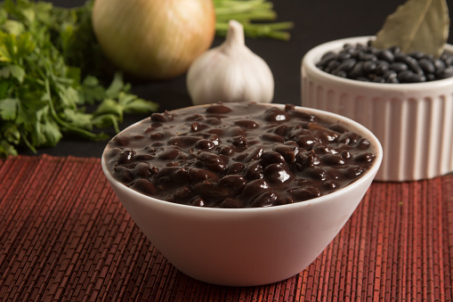 Cooked Black Beans in a bowl over a wooden table