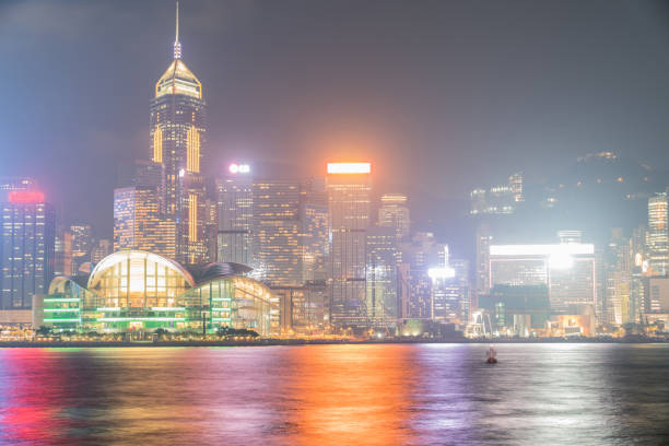 światła handlowej panoramy hongkongu odbijały się na spokojnej wodzie portu victoria. - refected zdjęcia i obrazy z banku zdjęć