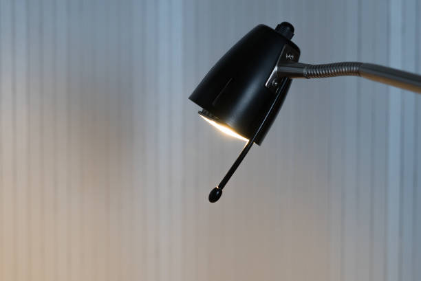 istock A lighted black reading lamp in front of white background with copy-space 943156040
