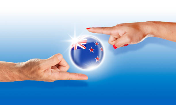 istock New Zealand button flag floating between with human hands 943166570