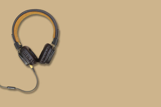 istock headphones on a sand color surface background, space for text 943168282