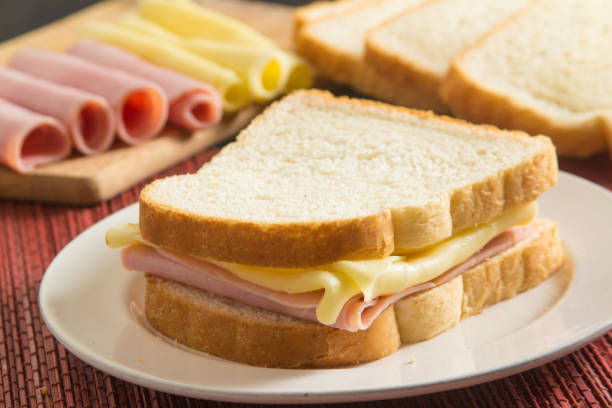Cheese and Ham Sandwich Cheese and Ham Sandwich over a wooden table ham and cheese sandwich stock pictures, royalty-free photos & images