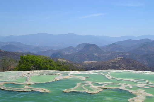 Shot of of one the 2 mineral pools of Hierve el Agua with the landscape in the background.