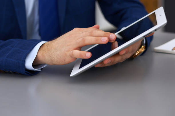 istock Businessman using touchpad at meeting, closeup of hands 943178442