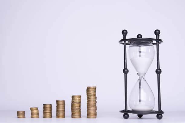 istock stacks of money and hourglass on a white background 943179130