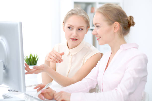 istock Two business ladies or colleagues discussing something in office background 943185246