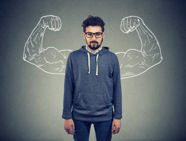 istock confident strong man hipster on wall background 943195166
