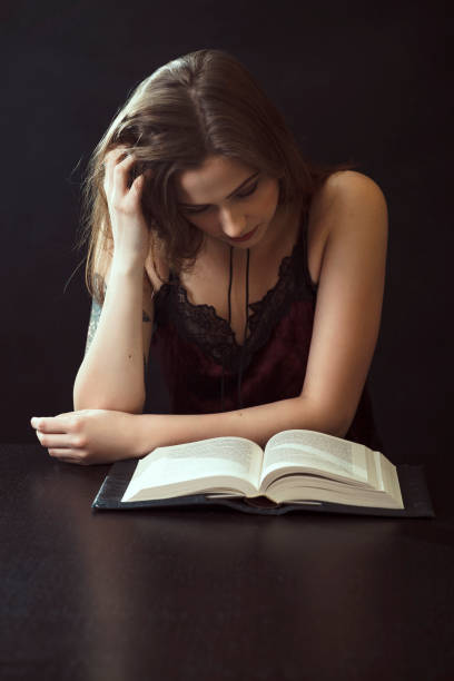 istock Young Woman Reading Book At Table 943204238