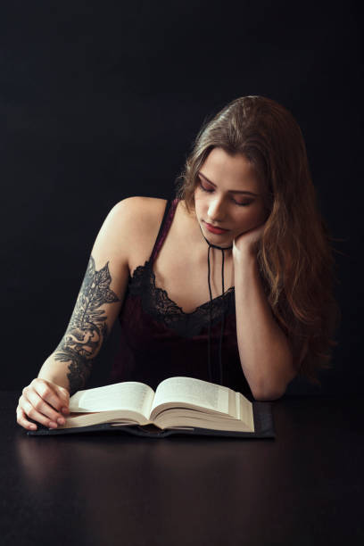 istock Young Woman Reading Book At Table 943204242