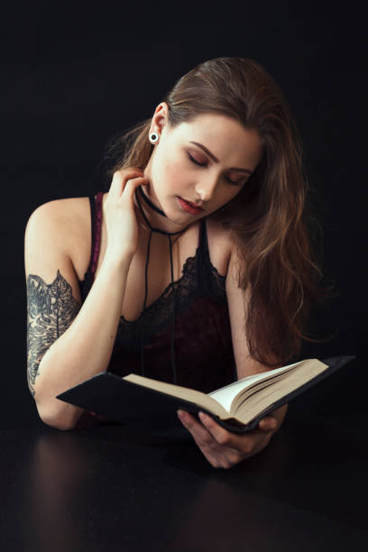 Young Woman Reading Book At Table
