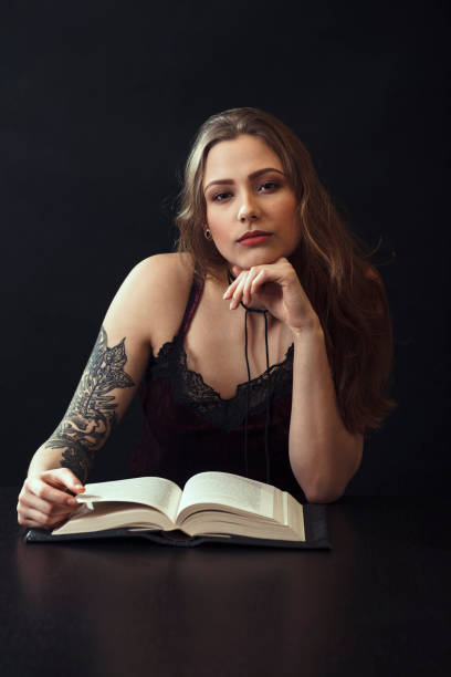 istock Young Woman Reading Book At Table 943204252