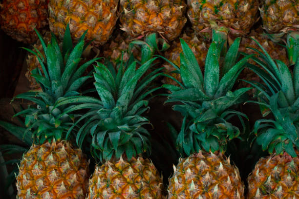 istock Row of fresh asian pineapples in fruit shop 943212630