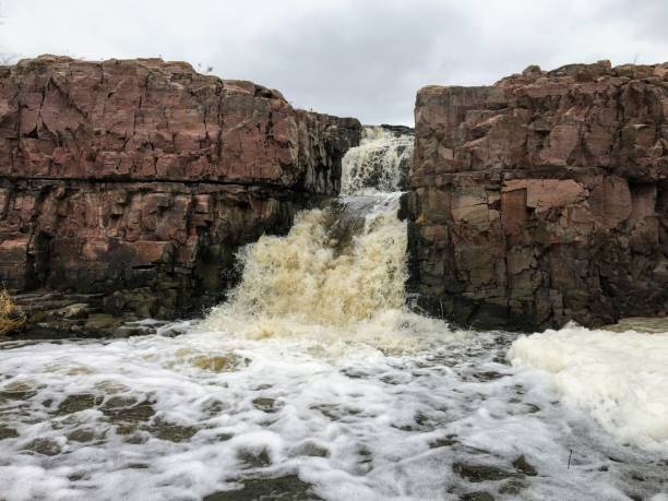 la big sioux rivière coule sur les rochers dans le dakota du sud de sioux falls, avec vue sur la faune, les ruines, les chemins du parc, train voie pont, arbres et ville dans les environs et arrière-plan - big sioux river photos et images de collection