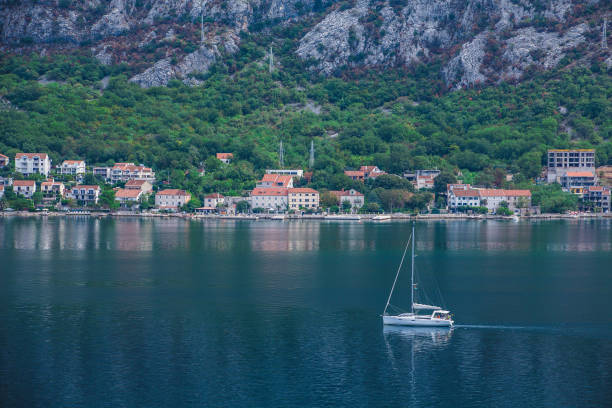 sailboat motoring beyond montenegro village - motoring imagens e fotografias de stock