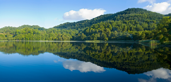 Cloud reflections ona rural lake in Hungary in the Panorama format