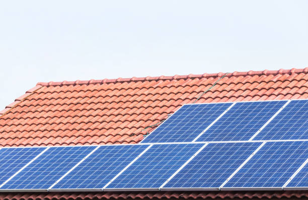 istock Close up rows array of polycrystalline silicon solar cells or photovoltaics installing on red concrete tiles roof house 943226512