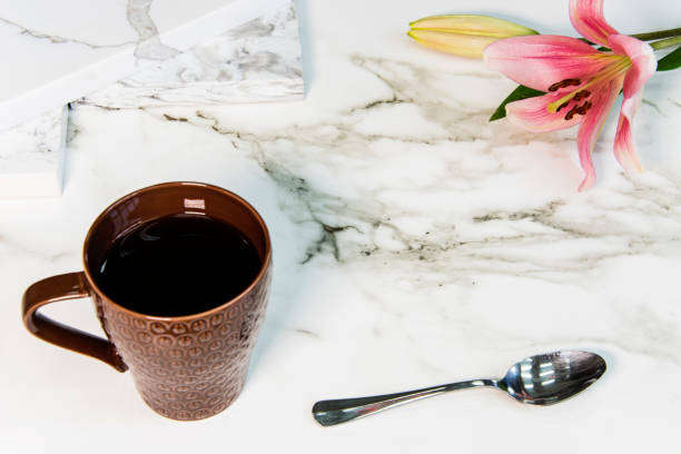 istock Marble kitchen counter with cup of coffee and flower on it 943232624