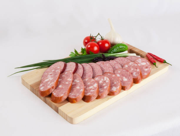 still life with sliced smoked sausage greens and tomatoes on a white background - smoked tongue imagens e fotografias de stock